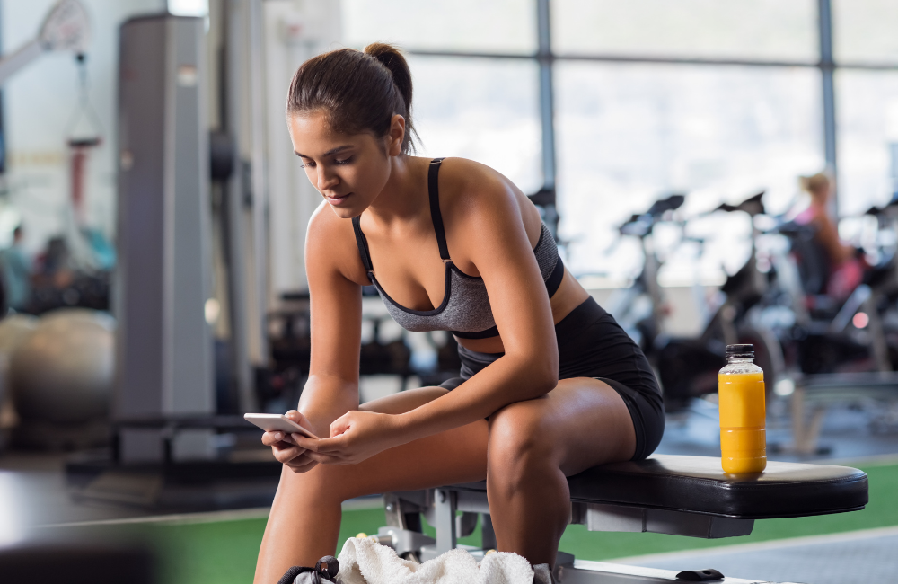 Fit person in gym reading client ebook
