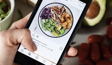 Phone showing a nutrition app beside fresh food